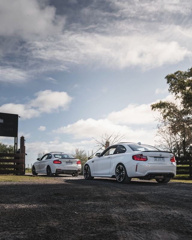 BMW M2 blanco y 135i coupé en la entrada